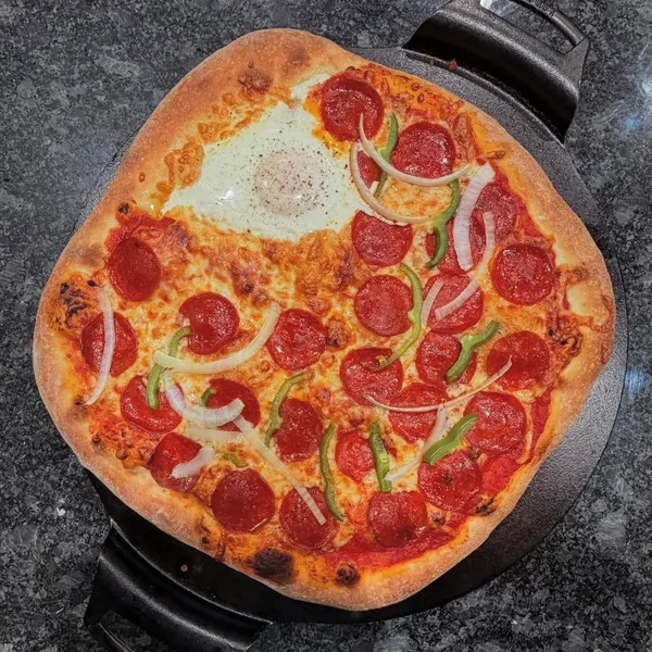 Pepperoni pizza with green peppers and onions in a cast iron pan