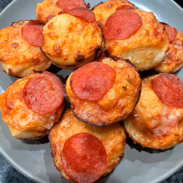 Individual deep-dish pepperoni pizza bites baked in a muffin tin