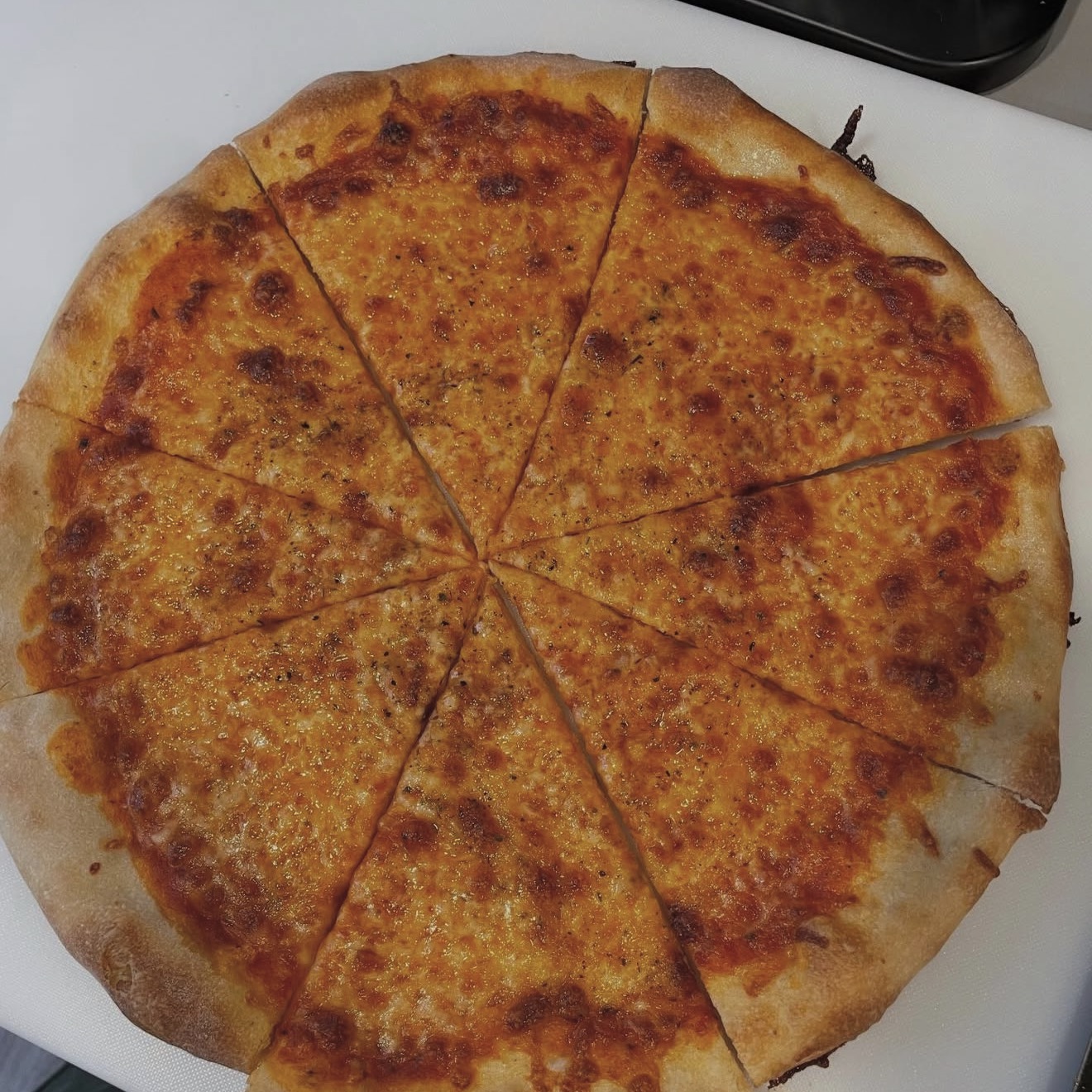 Classic cheese pizza sliced into eight pieces